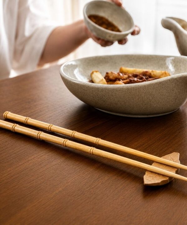 Baguette japonaise en bois naturel à côté d'un plat de cuisine japonaise
