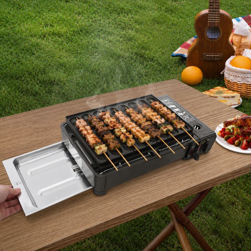 Barbecue japonais à gaz Yakitori avec brochettes grillées en extérieur sur une table de jardin