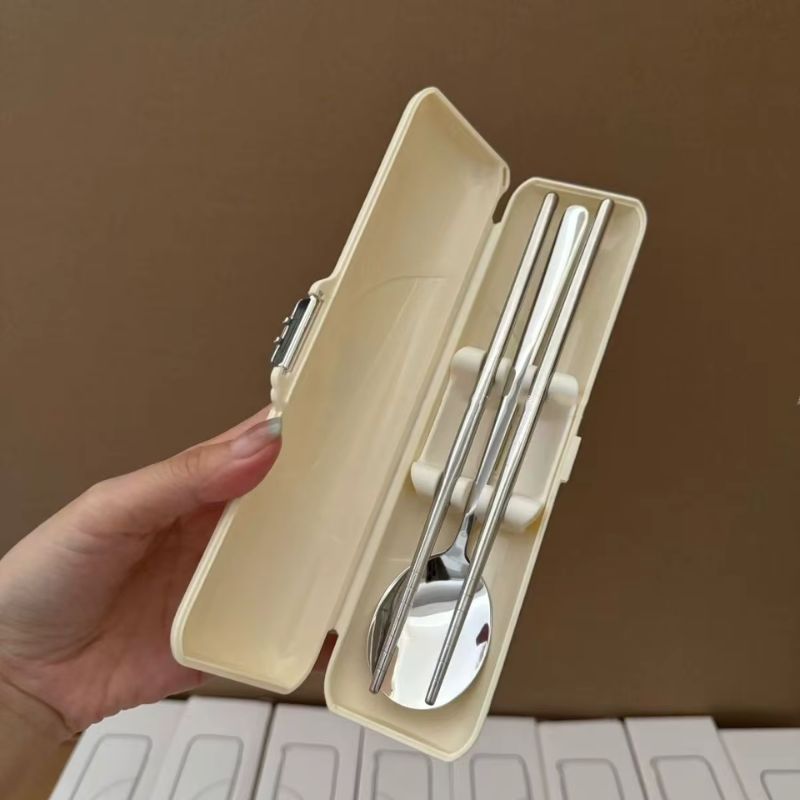 Étui ivoire ouvert contenant des baguettes coréennes et une cuillère en inox