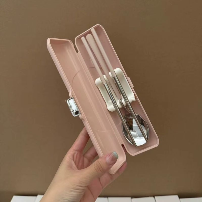 Étui rose ouvert contenant une paire de baguettes coréennes et une cuillère en inox