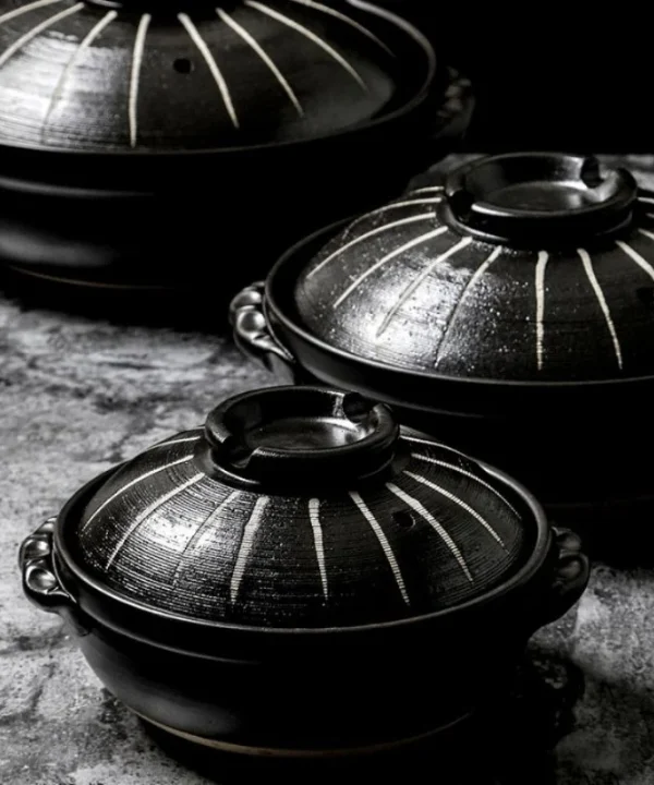 Trois marmites japonaises Donabe noires de tailles différentes, avec couvercles à rayures claires